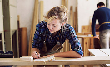 Woman sketching in wood working studio