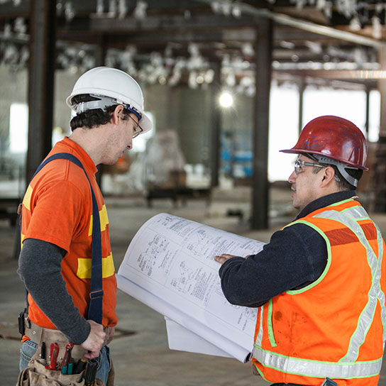 Construction workers reviewing blueprints