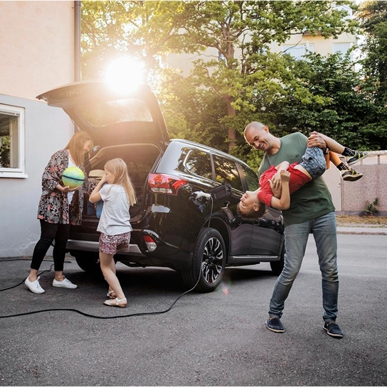 A family putting items in an electric car