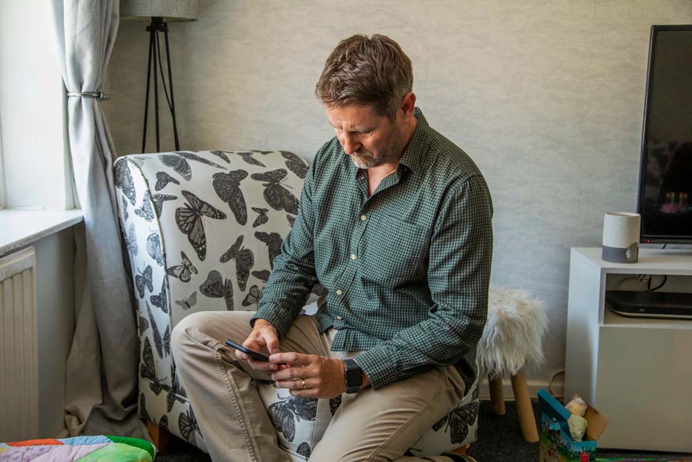 man sitting on chair with a smartphone