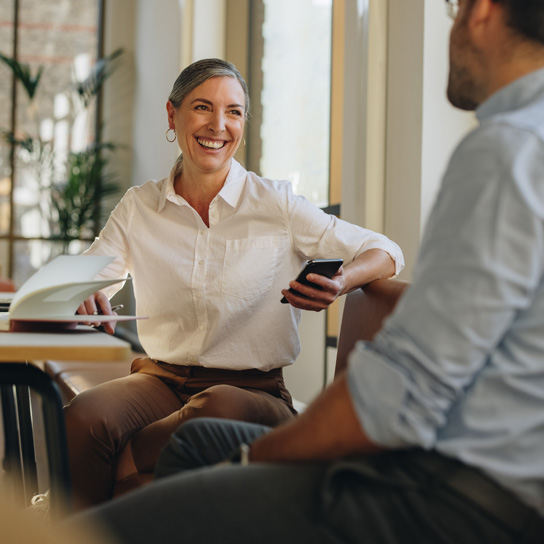 Photo of two colleagues talking in an office environment