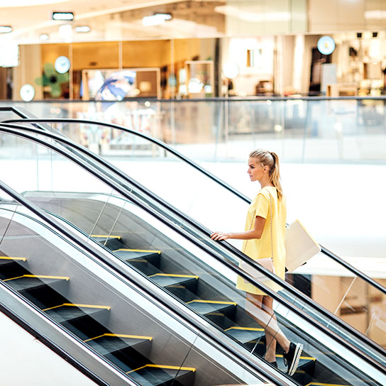 Woman on escalator in shopping centre