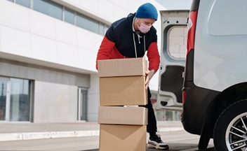 Man moving parcels into delivery van