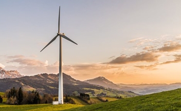 Single wind turbine against landscape