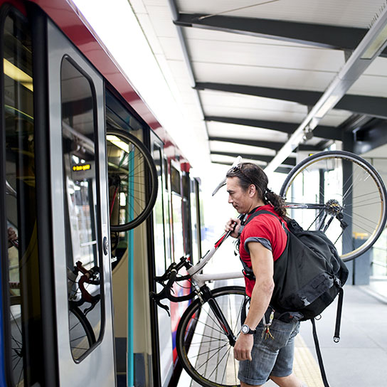 Man getting on train with bicycle