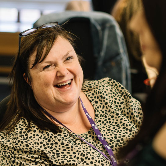 Woman laughing with colleague in Peterborough office