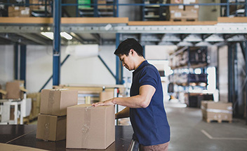 Man securing and packaging boxes