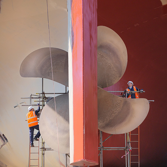 Close up of marine workers and ships rudder