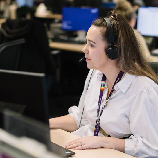 Young woman wearing headset in Peterborough office