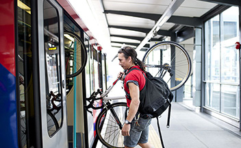 Man getting on train with bicycle
