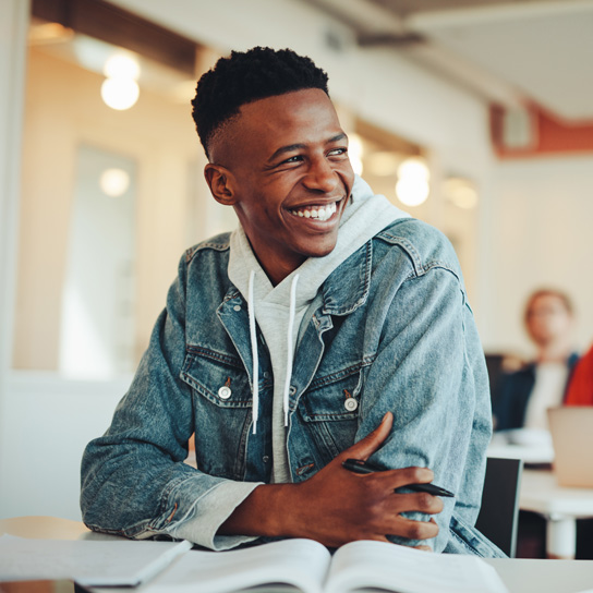 Photo of student sat in classroom smiling