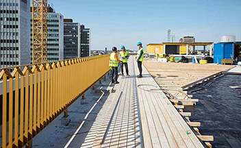 Construction workers talking on rooftop