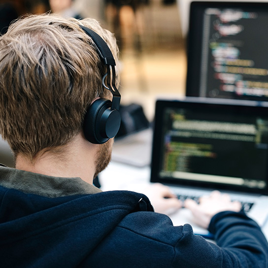 Man on computer wearing headphones