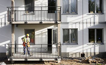 Construction worker on balcony of housing