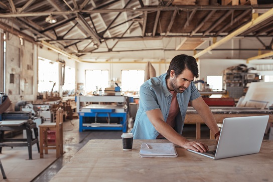 man in a workshop on a laptop