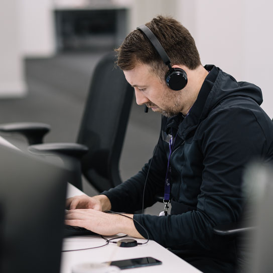 Man with headset typing in Liverpool office