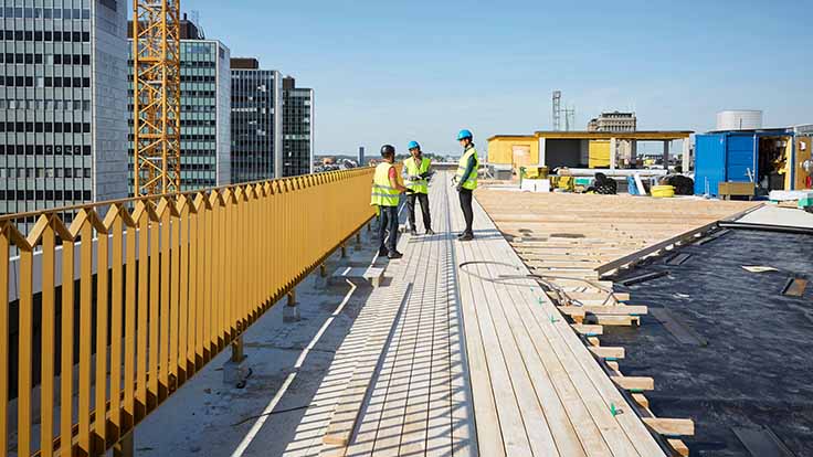 Construction workers talking on rooftop