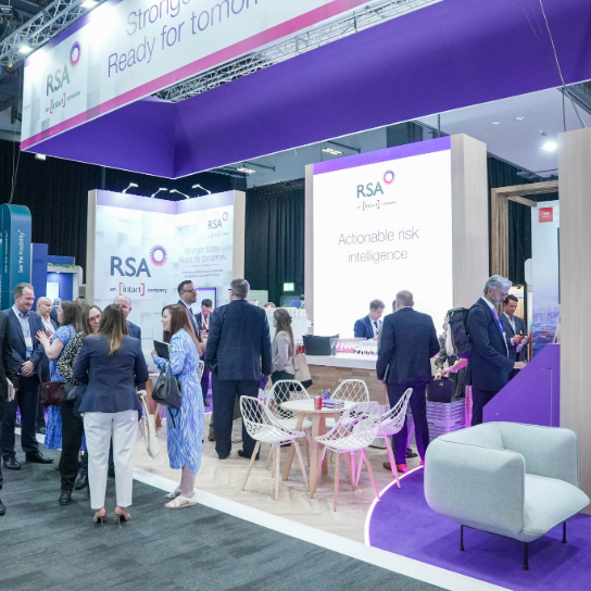 Photo of RSA colleagues at AIRMIC 2025, on our stand in discussion