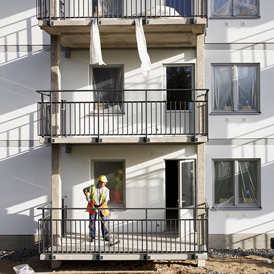 Construction worker on balcony of housing