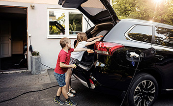 Children loading up boot of electric vehicle