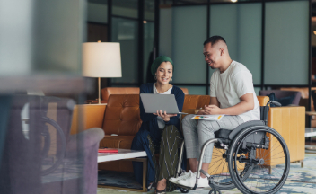 Woman and man in office talking with laptop