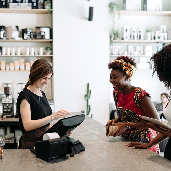 Two women in a shop, one making a purchase and the other using a till