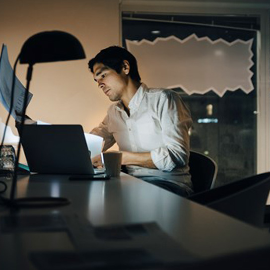 Man using laptop at home at night time