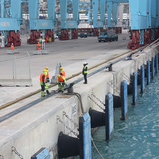 Marine workers on the side of shipping dock