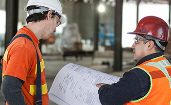 Construction workers reviewing blueprints