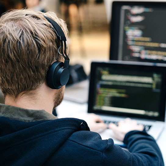 Man writing code on a laptop