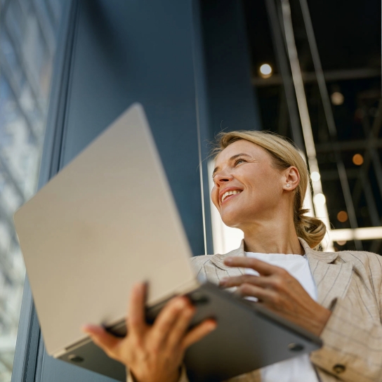 Lady smiling carrying a silver laptop