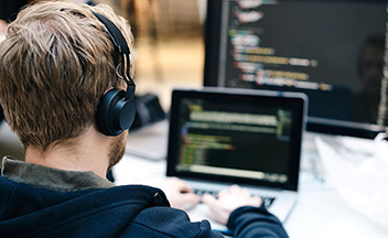 Man writing code on a laptop