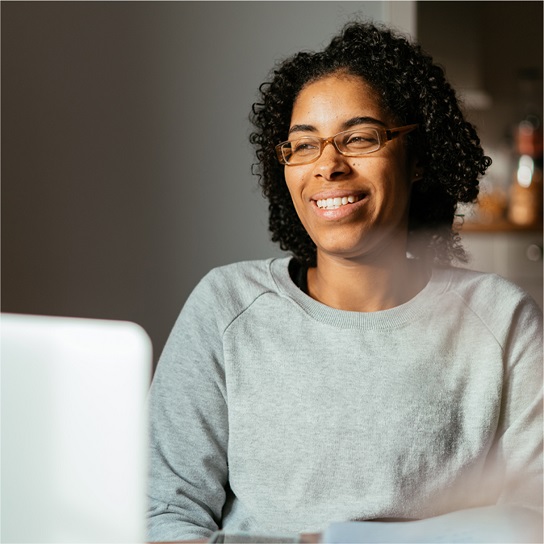 Smiling woman watching a computer screen