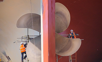 Close up of marine workers and ships rudder