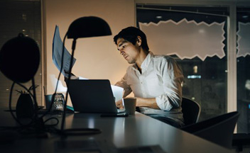 Man using laptop at home at night time