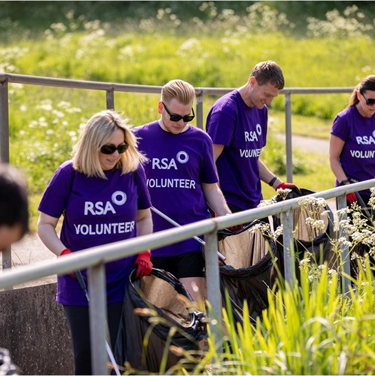 Three people wearing RSA volunteering t-shirts