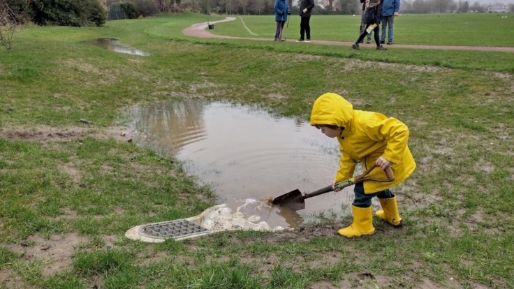 Photo of child at Naunton Park digging in a flooded corner