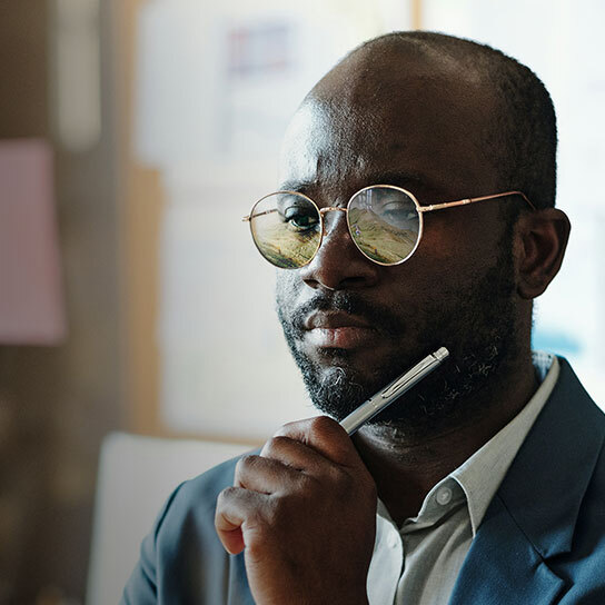 Man headshot, holding a pen, thinking.