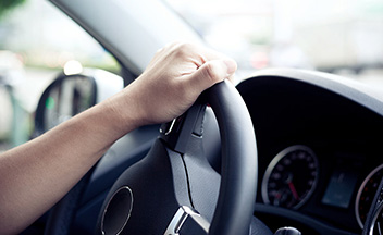 Close up of hand on steering wheel