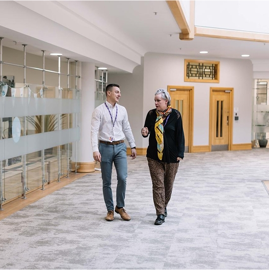 A man and woman walking in an office