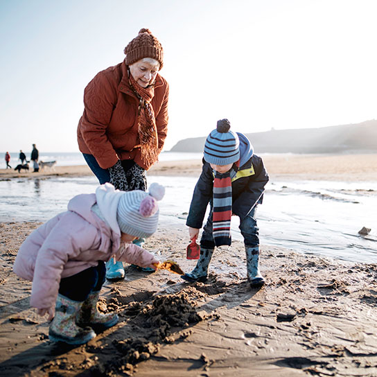 Older woman with young children on a beach