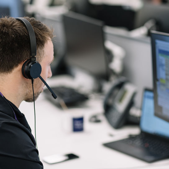 Man with headset and computer screen in Liverpool office