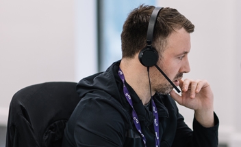 Man with headset at desk in Liverpool office