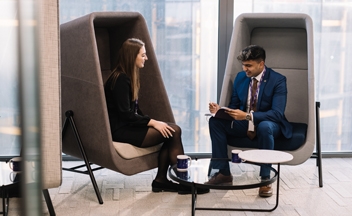 Man and woman sat in modern pod chairs in RSA London office